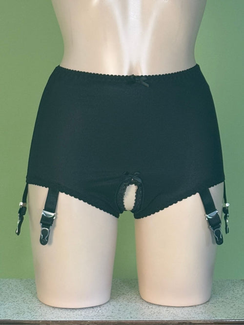 Black high-waisted garter belt briefs with attached suspenders, displayed on a beige mannequin against a green background.