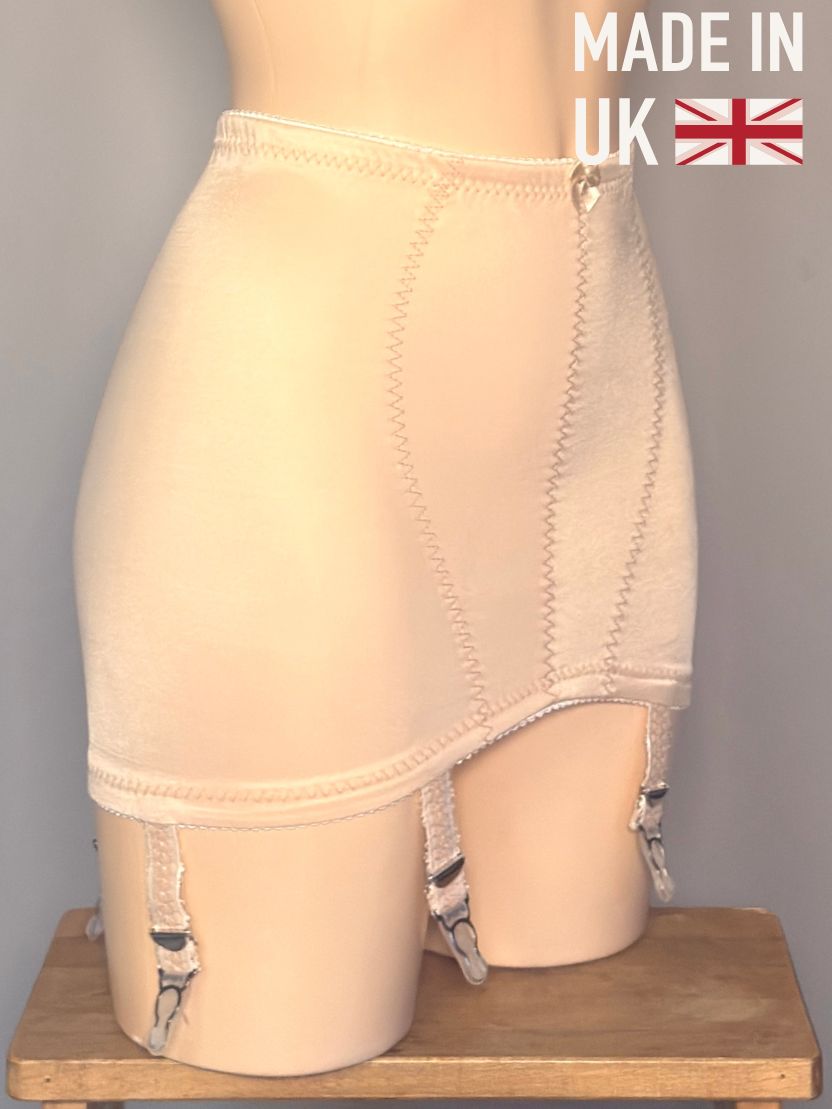 Beige high-waisted girdle with garter straps, displayed on a mannequin leg form. The image features a 'MADE IN UK' text overlay with a Union Jack flag in the top right corner, and the mannequin sits on a wooden stool against a neutral gray background.