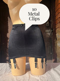 A black girdle with attached black garter straps and silver-toned metal clips, displayed on a beige mannequin. A white speech bubble overlay reads '10 Metal Clips'.