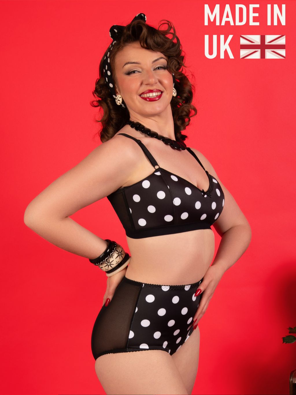 Woman wearing a black and white polka dot lingerie set with 'Made in UK' text on a red background.