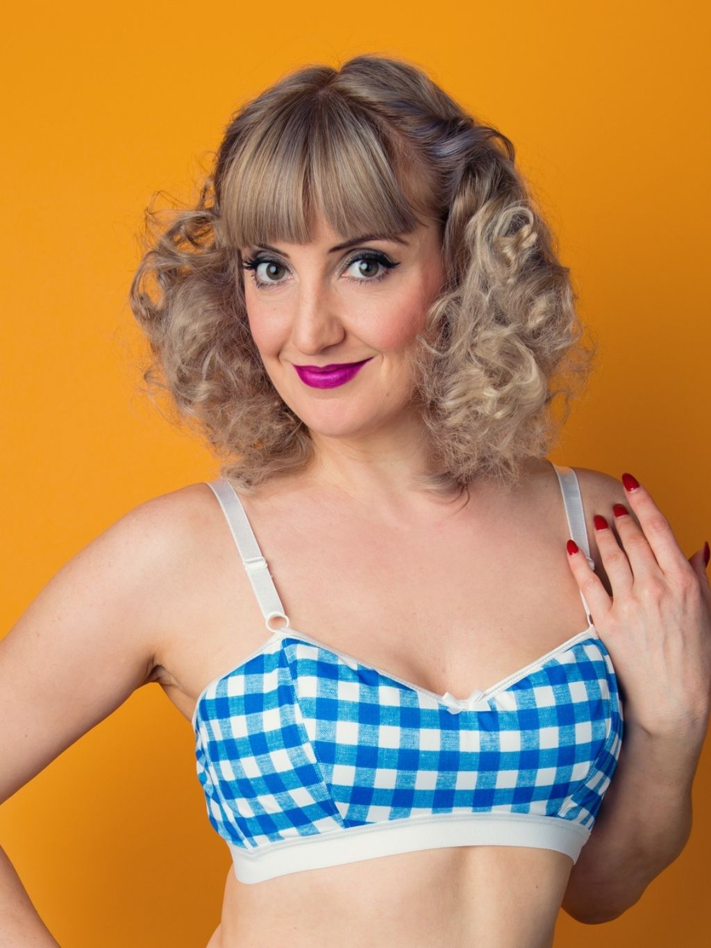Woman wearing a blue and white checkered bra against an orange background