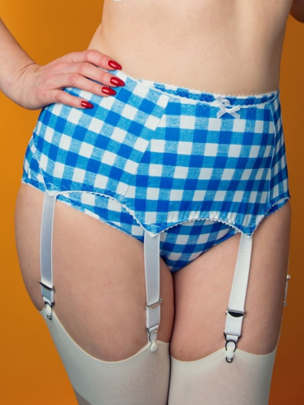 Blue and white checkered underwear with suspenders on a person against an orange background