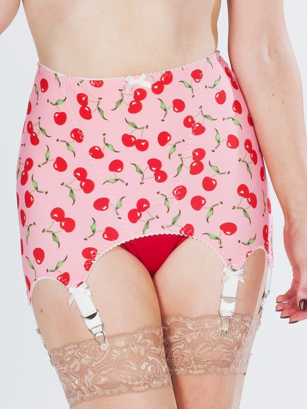 Pink girdle with cherry pattern worn by a person, with lace stockings visible.