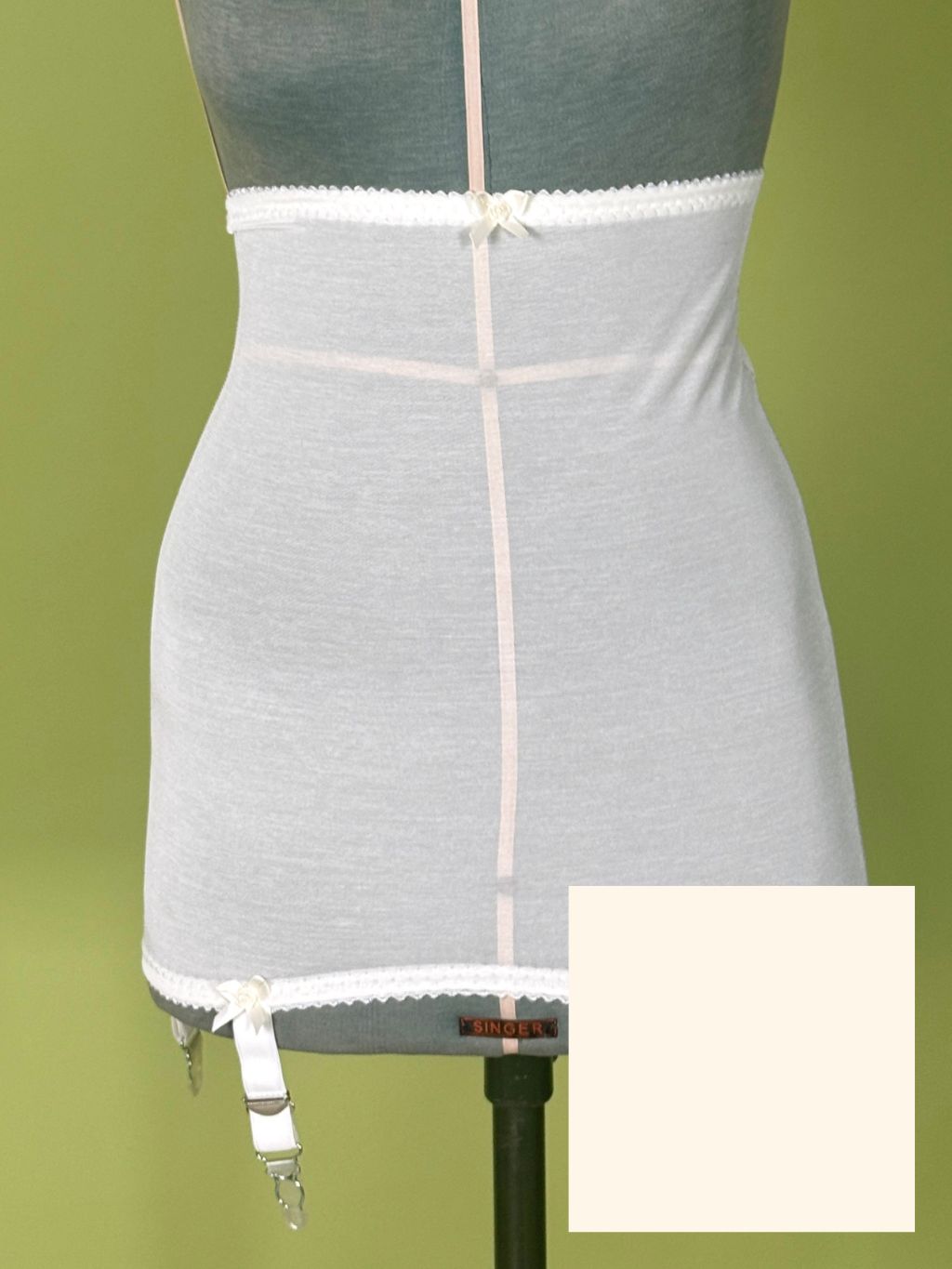 cream high waist girdle displayed on a torso mannequin against an olive green background, with a small inset color swatch in the bottom right corner.