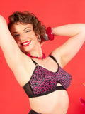 pink leopard cone bra on a red background