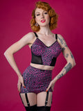 Woman wearing a leopard print lingerie set against a pink background