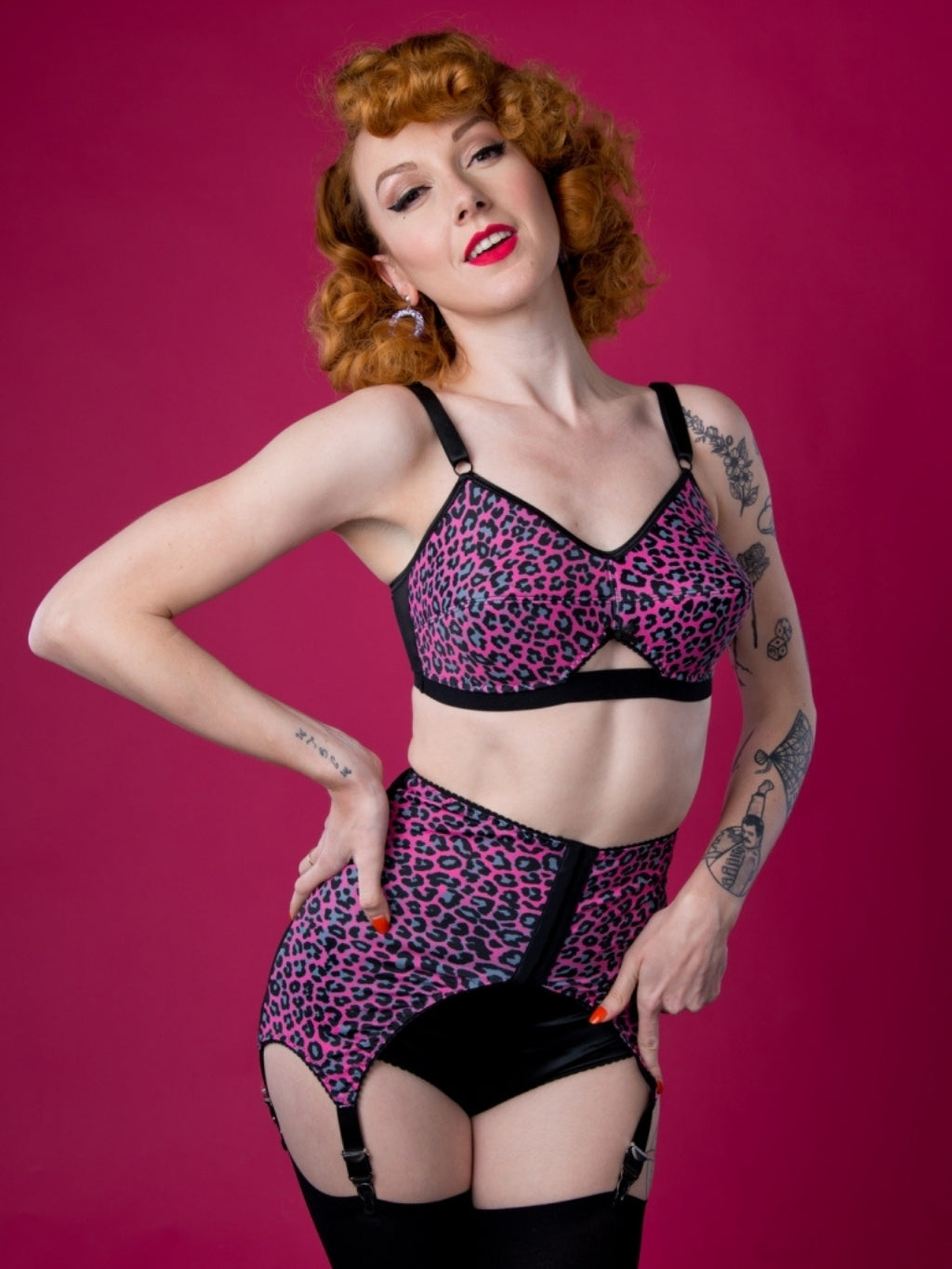 Woman wearing a leopard print lingerie set against a pink background