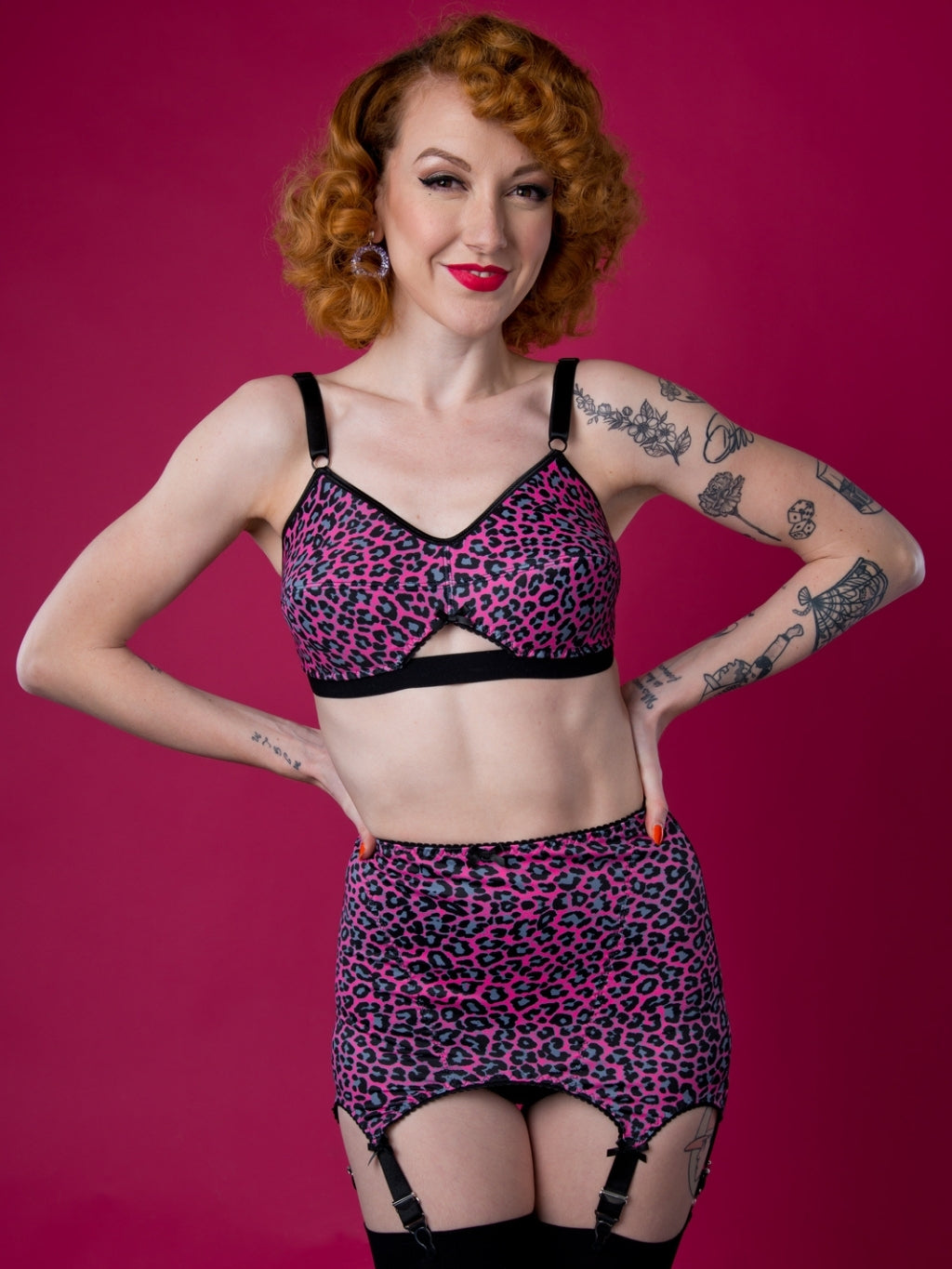 Woman wearing a leopard print lingerie set against a pink background