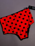 Red underwear with black polka dots on a gray background
