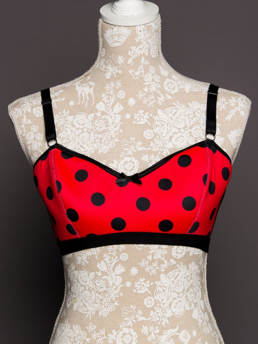 Red polka dot bra on a mannequin with lace background