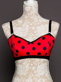 Red polka dot bra on a mannequin with lace background