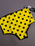 Yellow underwear with black polka dots on a gray background