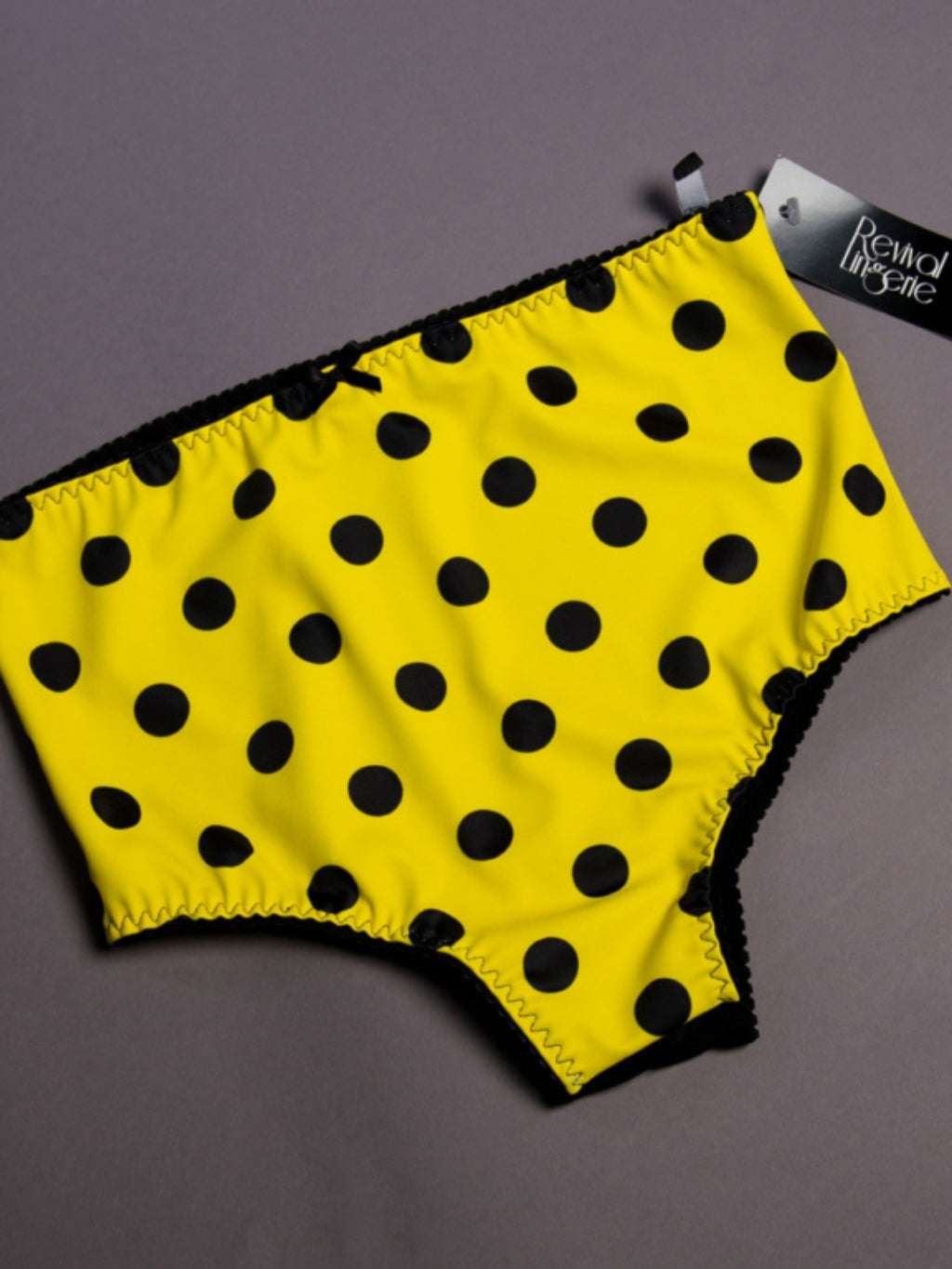 Yellow underwear with black polka dots on a gray background
